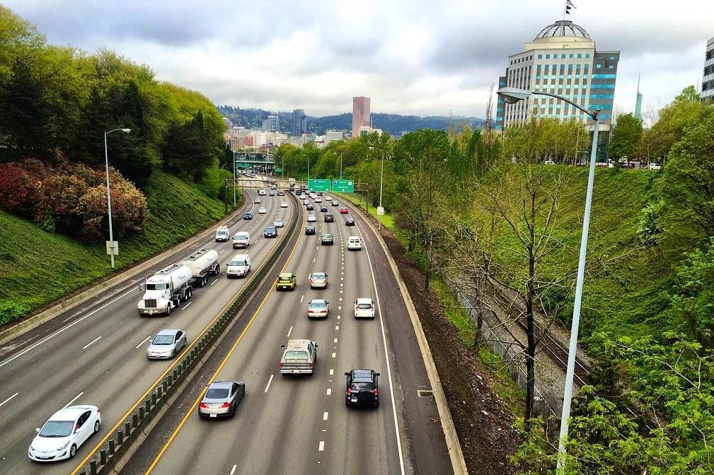 Cars on a highway, with a skyline in the background that is in Portland's Lloyd District.