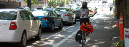 Person biking along protected bike lane near Portland State