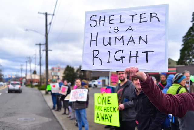 Pro-shelter protesters stand adjacent to busy Portland Arterial