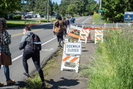 People walking single files in dangerous roadway