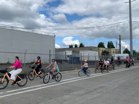 People of all ages riding BIKETOWN e-bikes, traditional bikes, kid bikes, and side-by-side bikes.