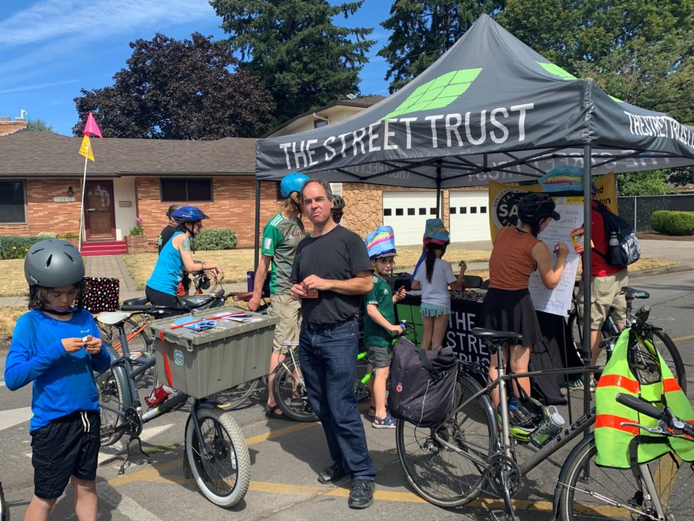A group of people on bikes visit TST's booth at Sunday Parkways
